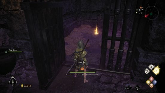 Wo Long Dragon's Vein Crystals Essences - the warrior has just unlocked a cell door with a key. Ahead is the essence next to a makeshift grave.